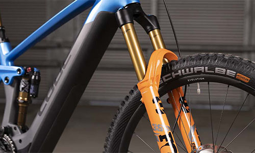Zu sehen ist ein blaues Fahrrad mit Fokus auf der Federung an der Gabel.